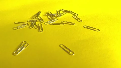 Falling metal paper clips on the table. Slow motion. Stock Footage 244209765