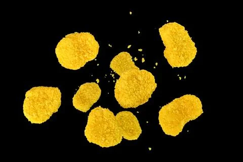 Falling nuggets isolated on a black background, selective focus. Fresh chic.. Stock-Fotos