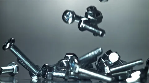 Falling nuts, bolts and washers on a metal table. Filmed on a high-speed camera Stock Footage 307937982