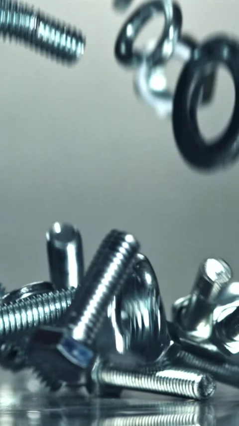 Falling nuts, bolts and washers on a metal table. Filmed on a high-speed camera Stock Footage 335369069