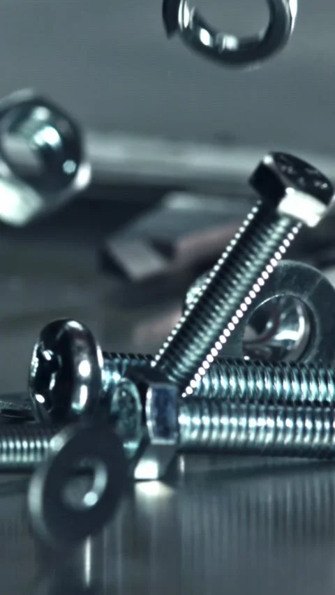 Falling nuts, bolts and washers on a metal table. Filmed on a high-speed camera Stock Footage 335370670