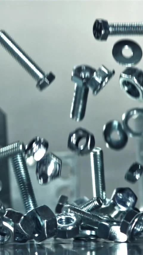 Falling nuts, bolts and washers on a metal table. Filmed on a high-speed camera Stock Footage 335370873