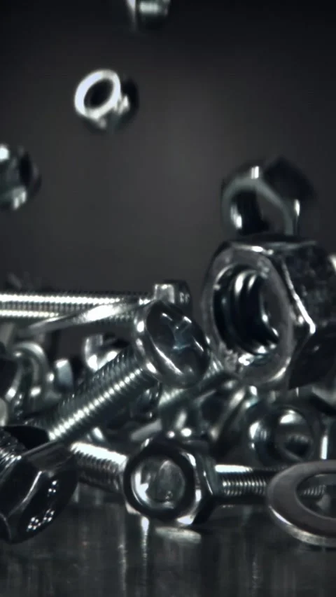 Falling nuts, bolts and washers on a metal table. Filmed on a high-speed camera Stock Footage 335370925