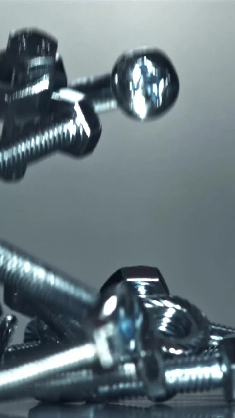 Falling nuts, bolts and washers on a metal table. Filmed on a high-speed camera Stock Footage 335372099