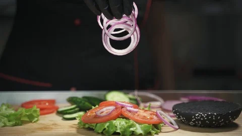 Falling onion on burger with vegetables Stock Footage 129685402