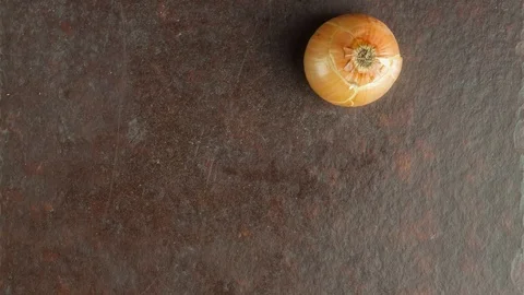 Falling onion on kitchen table stop motion Stock Footage 103626570