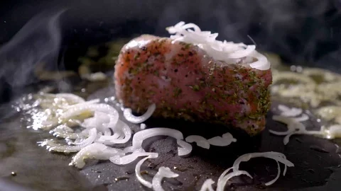 Falling onion to the pan with a piece of steak ham meat 4k Stock Footage 94264127