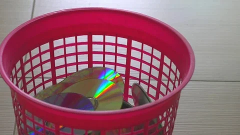 Falling of optical DVD or CD Discs in to red trash bin. Time lapse Stock Footage 76612784