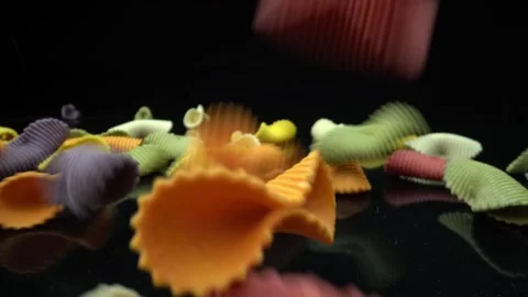 Falling pasta in the form of a shell in macro shot in super slow motion. On a Video stock 231403997