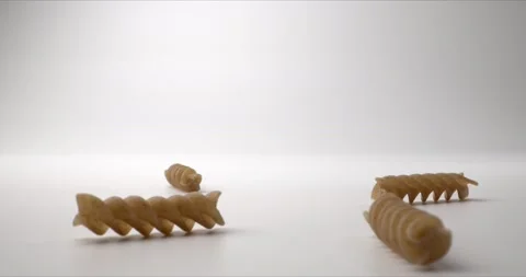 Falling pasta on white surface. Durum wheat pasta close up. Healthy whole grain Stock Footage 147035506