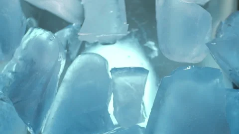 Falling pieces of ice crystals with blue illumination. Ice frozen background Stock Footage 262749712
