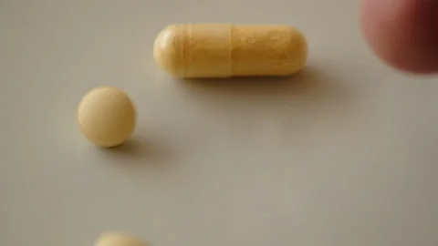 Falling pills and capsules on the light surface in slow motion Stock Footage 170598873