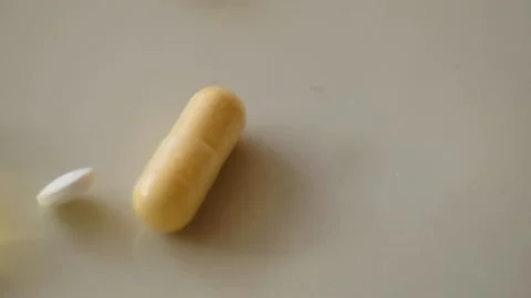 Falling pills and capsules on the light surface in slow motion Stock Footage 170598889