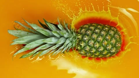 Falling Pineapple Pieces into Juice. Stock Footage 247633347