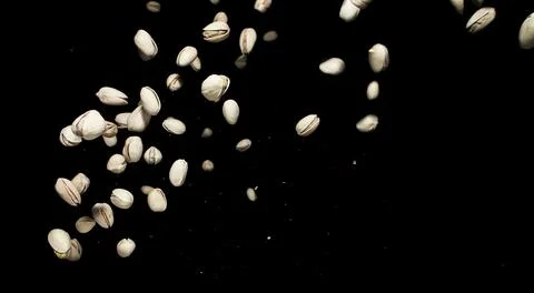 Falling pistachio nuts isolated on black Stock Photos
