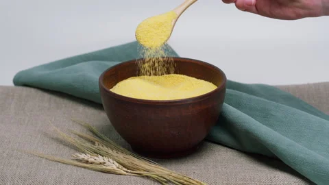 Falling polenta from wood spoon into bowl. Shooting of stirring cereal and Stock-Footage 157449900