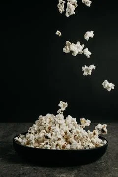 Falling pop corn on black background Stock Photos