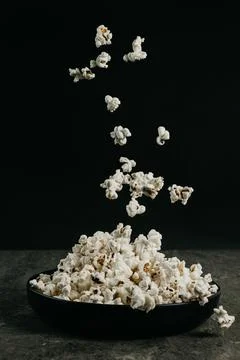 Falling pop corn on black background Stock Photos