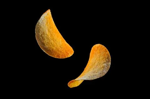 Falling potato chips isolated on black background Foto stock