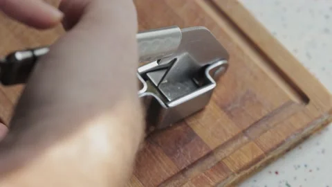 Falling pressed garlic from a metal press, close up Stock Footage 219699165