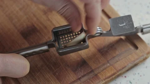 Falling pressed garlic from a metal press, close up Vídeo Stock 219705682