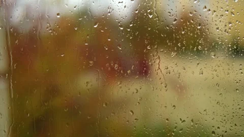 Falling rain drops on window surface close-up. Natural autumn red and yellow Stock Footage 270213167