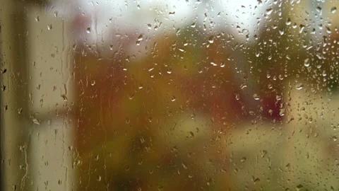 Falling rain drops on window surface close-up. Natural autumn red and yellow Stock Footage 287920731