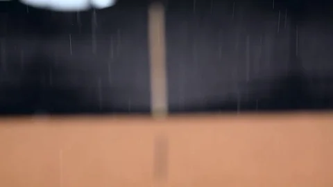 Falling rain storm, on a black and orange out of focus building background Stock Footage 78828072