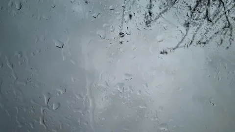 Falling rain water drops motion on a glass during a rainstorm, climate changes Stock Footage 221658834