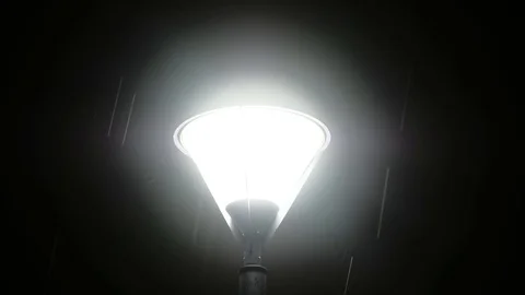Falling raindrops on the background of a glowing lamp in the dark Stock Footage 126373724