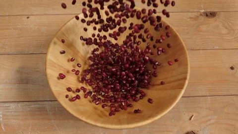 Falling red adzuki beans into wooden bowl, slow motion shot Stock Footage 116668536
