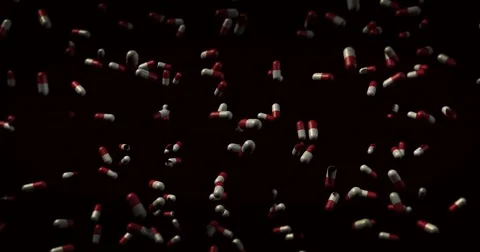 Falling Red and White Capsule pills falling over black - drug overdose concept Stock Footage 76814342