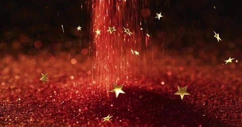 Falling red particle column streaming over glitter mound in studio close-up, Stock Photos