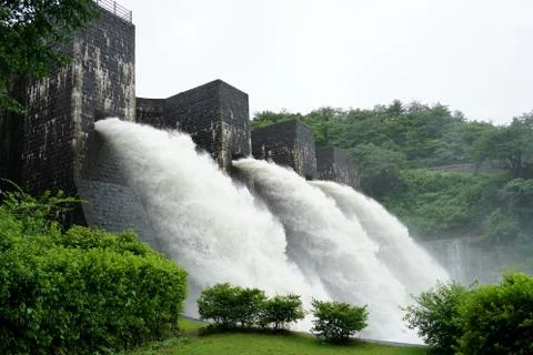 Falling river water in old bricked dam Stock Photos