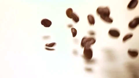 Falling roasted coffee beans covering white background, super slow motion shot Stock Footage 66690115