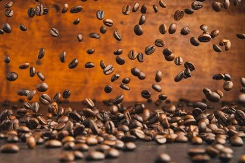 Falling roasted coffee beans. Stock Photos