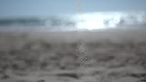 Falling sand at the beach, shot against the sun flare sandy beach slow motion Stock Footage 100165056