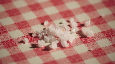 Falling Sea salt on a checkered kitchen table with red and white 库存影片 162623989