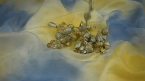 Falling shiny gold bijouterie on a gradient pastel soft fabric in slow motion. Stock Footage 120190577