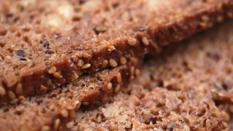 A falling slice of dark whole grain German rye bread Stock Footage 331802990