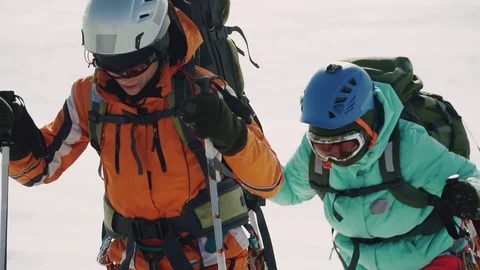 Falling snow and stumbling from fatigue, a group of climbers climb on a big Stock Footage 105874345