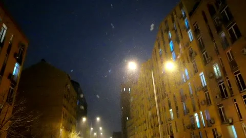 Falling snow backlit with modern street lamp in city street at night in winter. Video stock 183043971