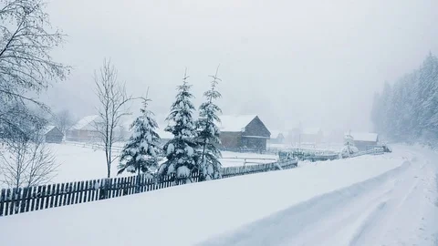 Falling snow with a big gust of wind against the background of the village. Stock Footage 127230309