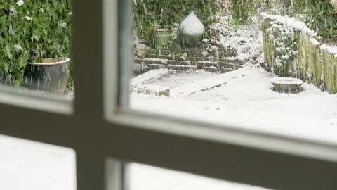 Falling snow in a garden behind window Stock Footage 235894882