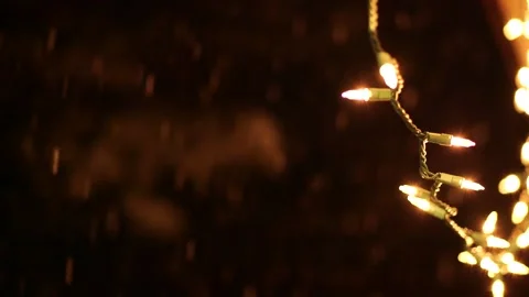 Falling snow at night with glowing string lights Stock Footage 306415552
