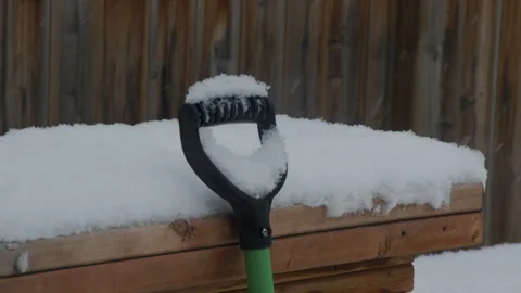 Falling snow shovel handle close up in backyard Stock Footage 295920336
