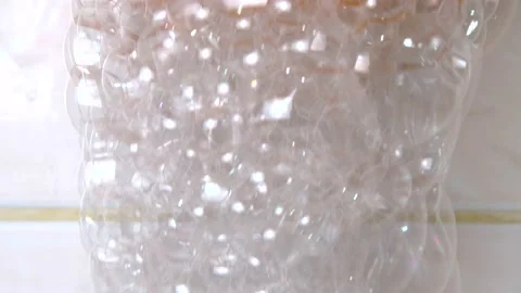 Falling soap bubbles in the bathroom against a tiled background, Stock Footage 235617591
