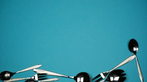 Falling spoons and forks on the blue background. Stock Footage 88059573