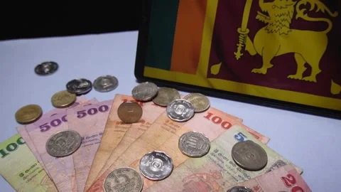 Falling Sri Lankan Coins onto Table with Notes and Flag Stock Footage 300096399