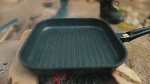 Falling stack of beef in a pan that is heated on a fire in nature outdoors Stock Footage 264141850